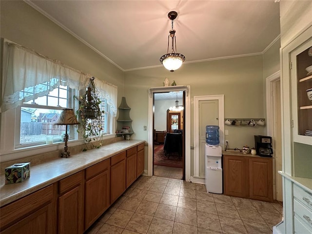 kitchen with ornamental molding, light tile patterned floors, and decorative light fixtures