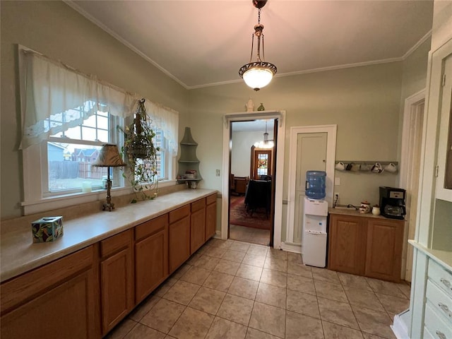 kitchen with crown molding, decorative light fixtures, and light tile patterned flooring