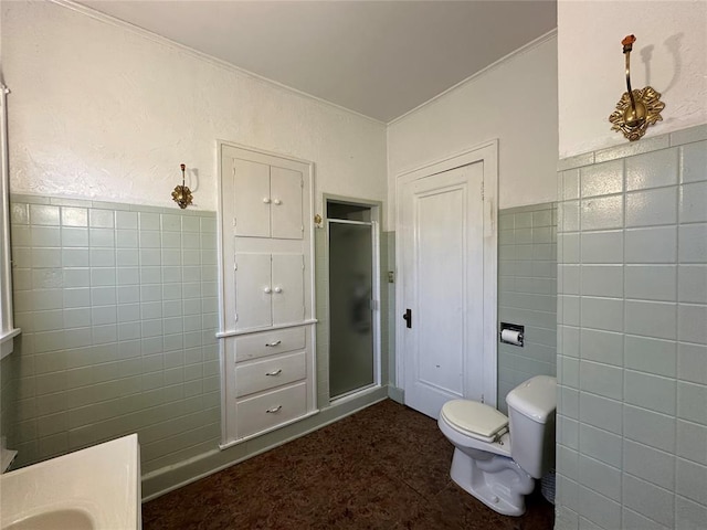 bathroom featuring tile walls, a shower with door, and toilet