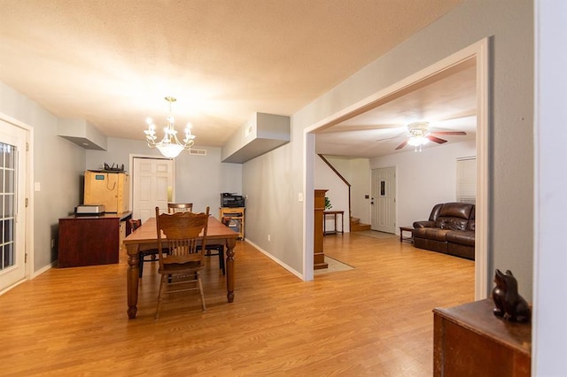 dining area featuring ceiling fan with notable chandelier and light hardwood / wood-style flooring