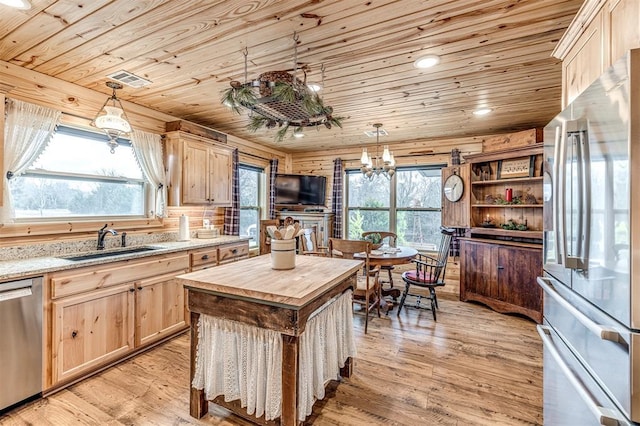 kitchen with appliances with stainless steel finishes, sink, hanging light fixtures, wood ceiling, and light brown cabinets