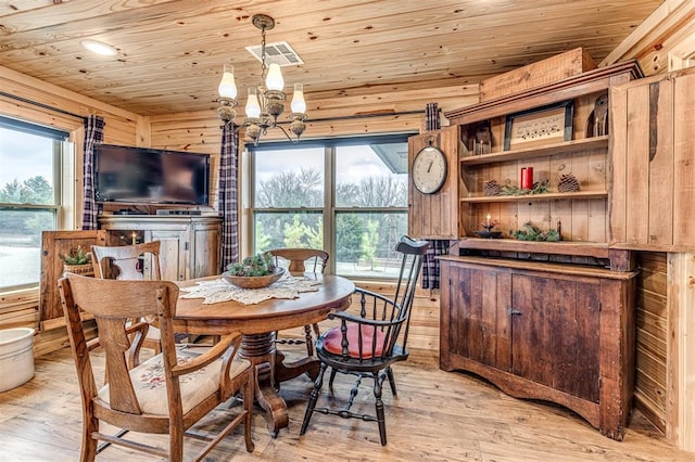 dining space featuring a healthy amount of sunlight, a chandelier, light hardwood / wood-style floors, and wooden ceiling