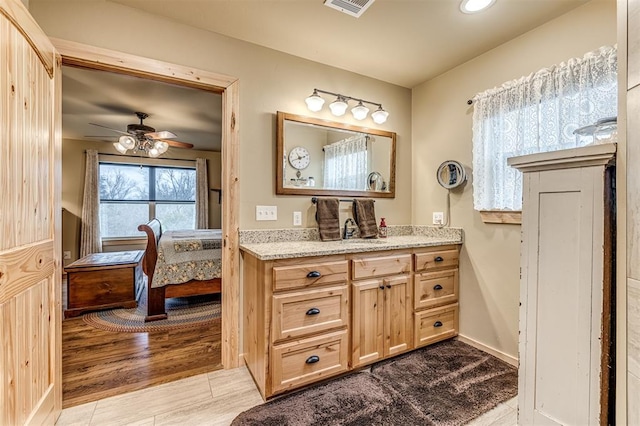 bathroom with hardwood / wood-style flooring, vanity, and ceiling fan