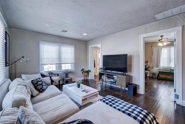 living area with visible vents, baseboards, and hardwood / wood-style flooring