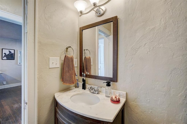 bathroom featuring wood finished floors, vanity, and a textured wall