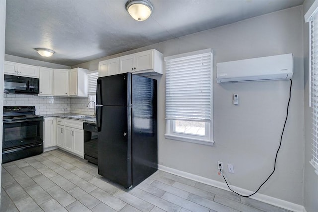 kitchen featuring decorative backsplash, white cabinets, an AC wall unit, and black appliances