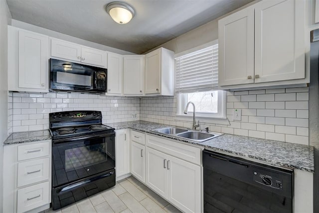 kitchen with black appliances, a sink, tasteful backsplash, white cabinetry, and light stone countertops