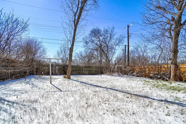 snowy yard featuring fence