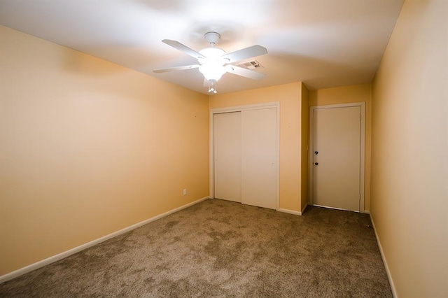 unfurnished bedroom featuring dark carpet, a closet, and ceiling fan