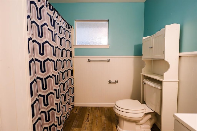 bathroom featuring hardwood / wood-style floors, a shower with shower curtain, and toilet