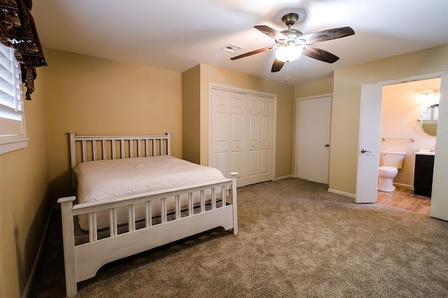 bedroom featuring connected bathroom, light colored carpet, a closet, and ceiling fan