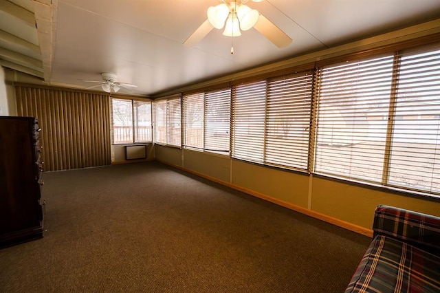 unfurnished sunroom with ceiling fan