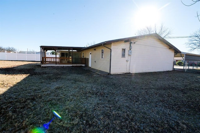 back of house featuring a wooden deck and a lawn