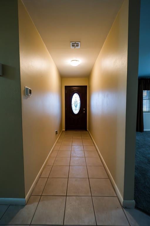 doorway to outside featuring visible vents, baseboards, and light tile patterned flooring