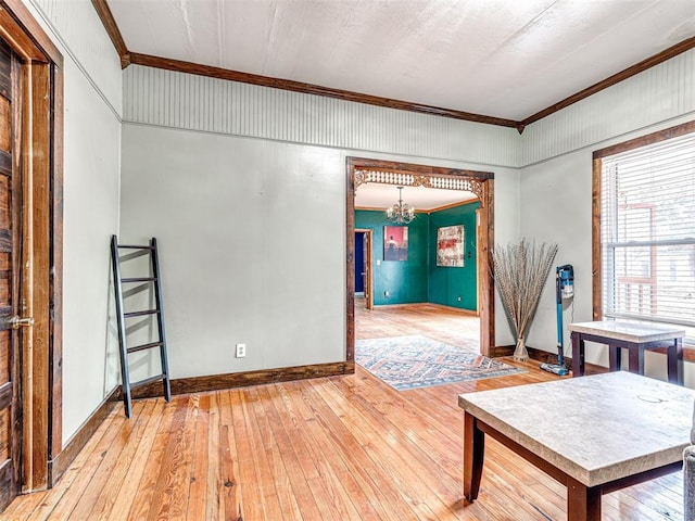 interior space with crown molding, wood-type flooring, and a chandelier