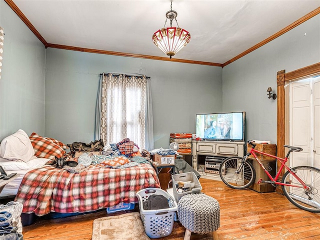 bedroom with ornamental molding and light hardwood / wood-style floors