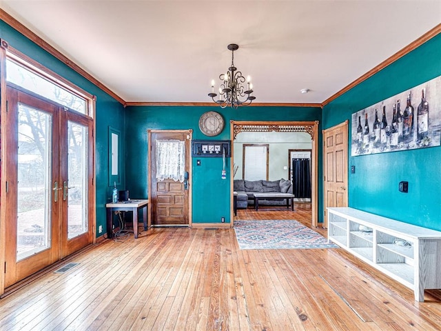 entrance foyer with ornamental molding, wood-type flooring, and plenty of natural light