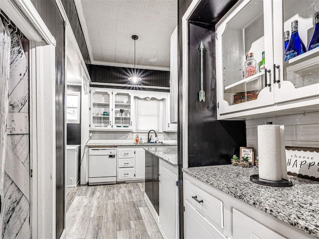 kitchen featuring light stone counters, light hardwood / wood-style flooring, dishwasher, pendant lighting, and white cabinets