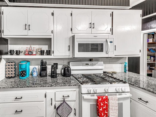 kitchen with stone countertops, backsplash, white cabinets, and white appliances