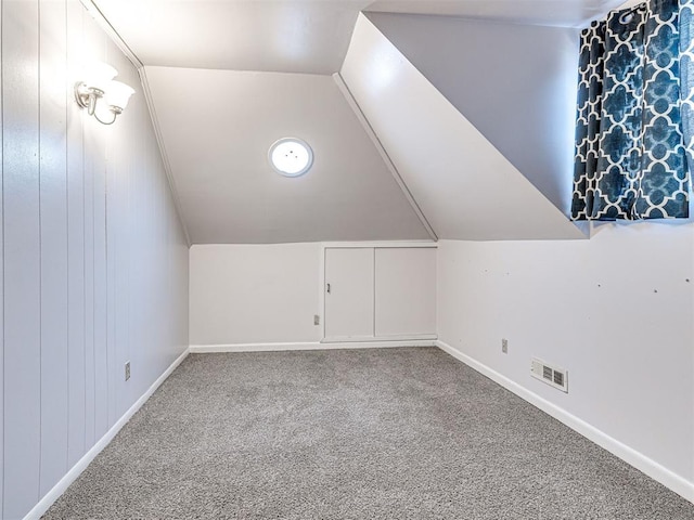 additional living space with vaulted ceiling and carpet flooring