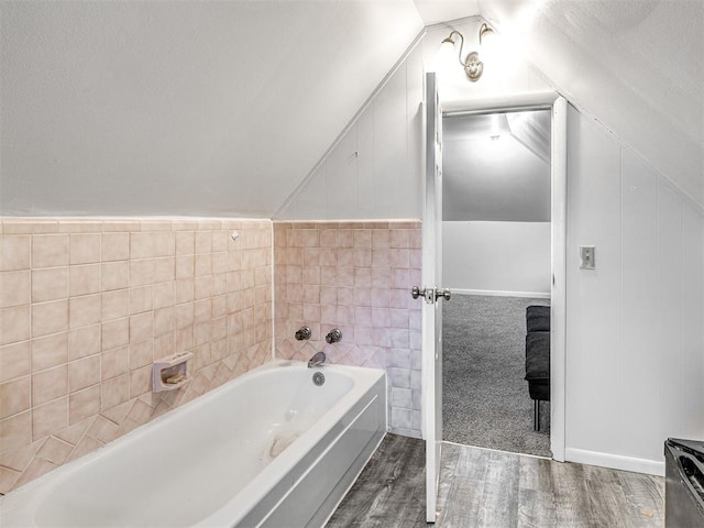 bathroom featuring a bathing tub, lofted ceiling, and hardwood / wood-style floors