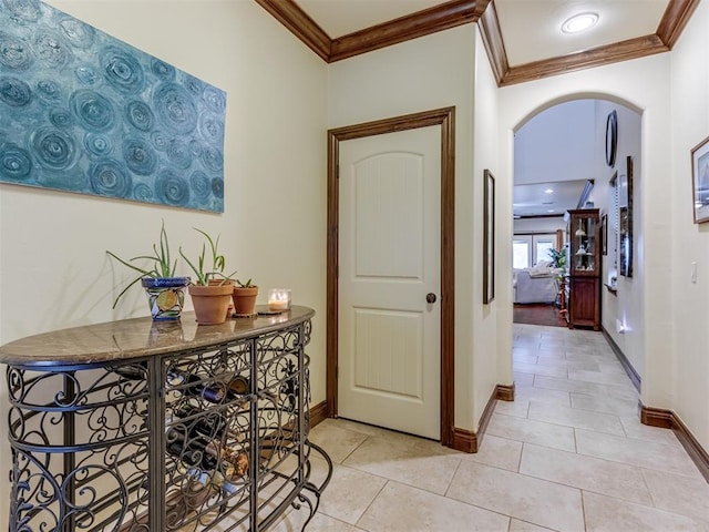 corridor with light tile patterned flooring and ornamental molding