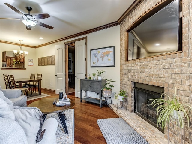 living room featuring crown molding, a fireplace, dark hardwood / wood-style floors, and ceiling fan