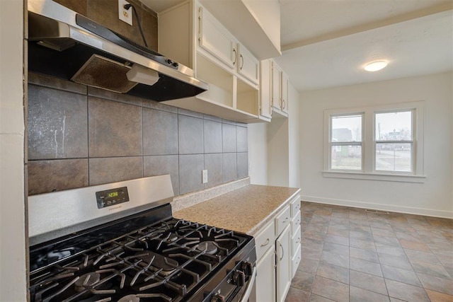 kitchen featuring white cabinetry, light tile patterned floors, decorative backsplash, and stainless steel gas stove