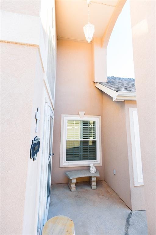 view of side of property with roof with shingles and stucco siding