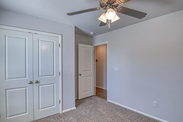 unfurnished bedroom featuring ceiling fan, a closet, carpet, and baseboards