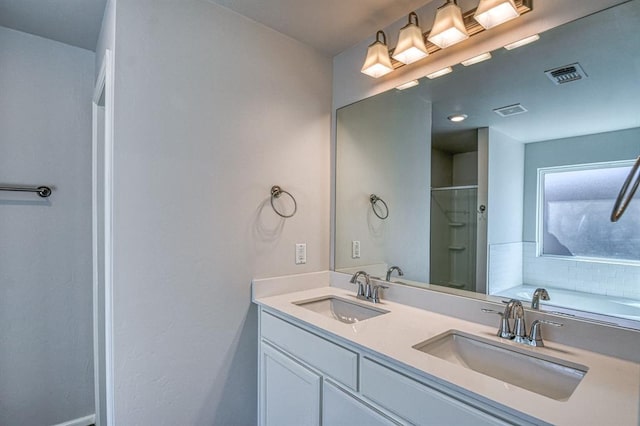 full bath with visible vents, a sink, a shower with door, and double vanity