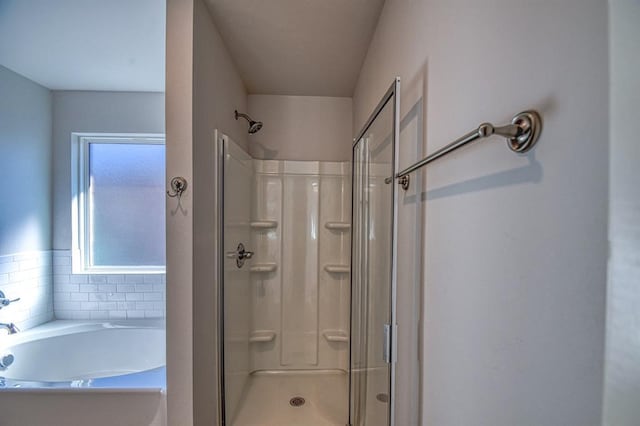 bathroom with a garden tub and a shower stall