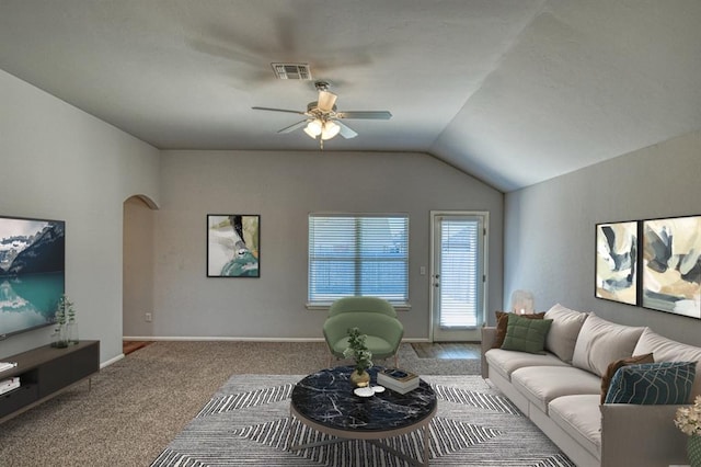 carpeted living room featuring arched walkways, ceiling fan, visible vents, baseboards, and vaulted ceiling