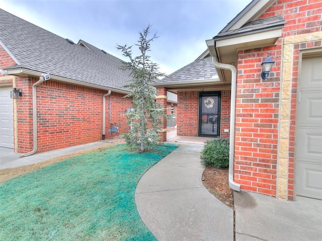 property entrance featuring a garage and a lawn