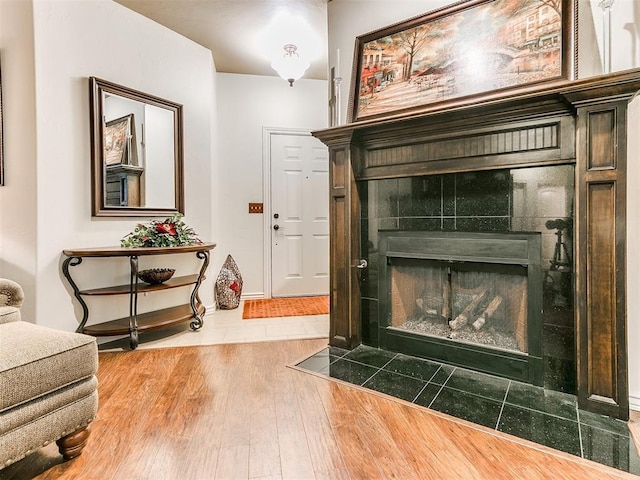 details with hardwood / wood-style flooring and a tile fireplace