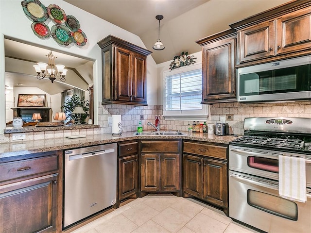 kitchen featuring lofted ceiling, sink, appliances with stainless steel finishes, tasteful backsplash, and dark brown cabinetry