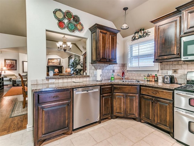 kitchen with tasteful backsplash, appliances with stainless steel finishes, sink, and vaulted ceiling