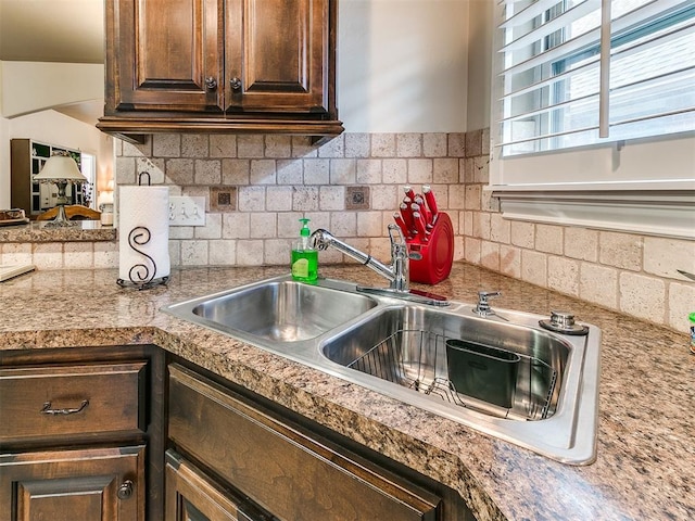 kitchen with dark brown cabinetry, sink, and decorative backsplash