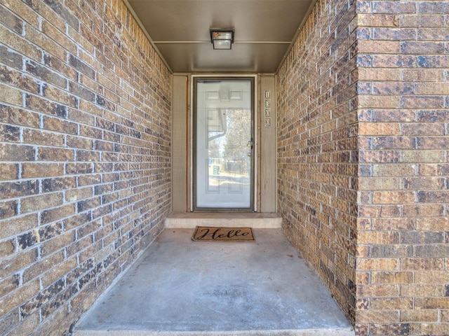 view of exterior entry with brick siding