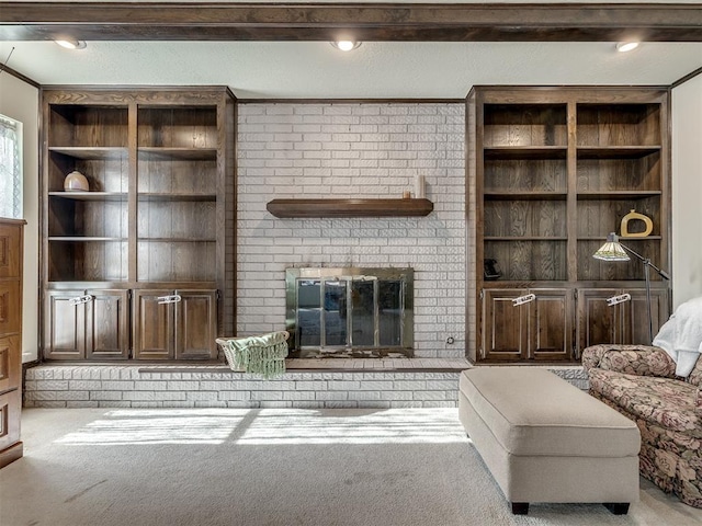 carpeted living room with built in shelves, a fireplace, and crown molding