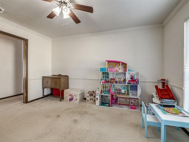 playroom featuring carpet floors, a textured ceiling, ornamental molding, and a ceiling fan