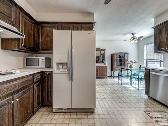 kitchen featuring light floors, light countertops, appliances with stainless steel finishes, dark brown cabinets, and under cabinet range hood