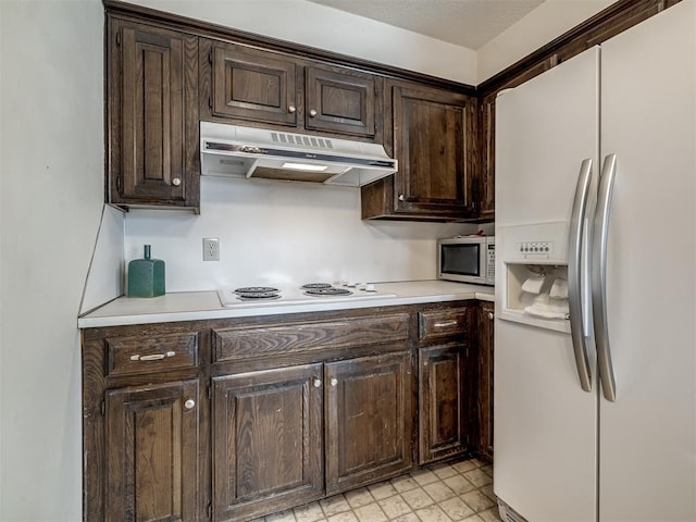 kitchen with white appliances, under cabinet range hood, light countertops, and dark brown cabinets