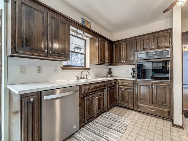 kitchen with light countertops, stainless steel dishwasher, a sink, dark brown cabinets, and black oven