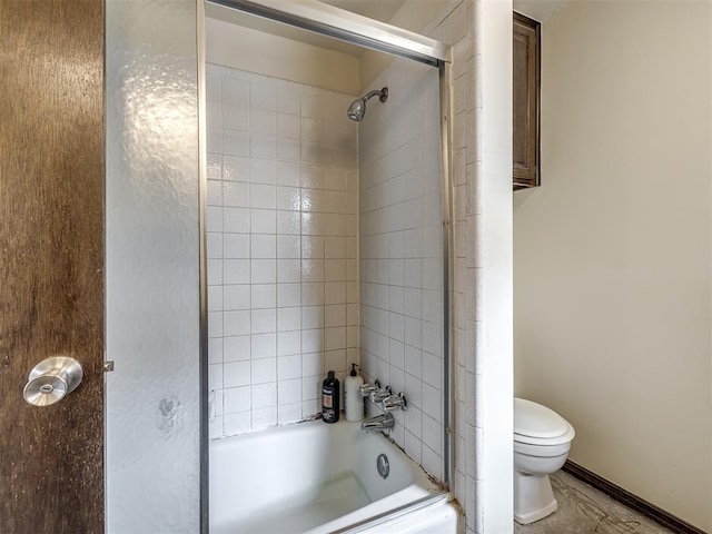 bathroom with toilet and shower / bath combination with glass door