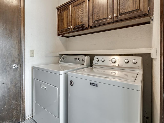 clothes washing area featuring cabinet space and independent washer and dryer