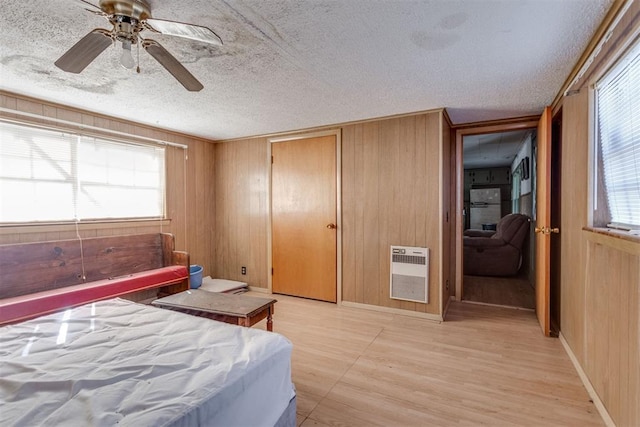 21731 E Fifth St, Hinton, OK 73047 - bedroom with ceiling fan, wooden walls, heating unit, and a textured ceiling