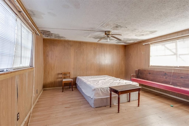 21731 E Fifth St, Hinton, OK 73047 - bedroom with a textured ceiling, light hardwood / wood-style floors, and wood walls