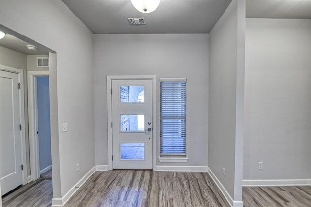 entryway with baseboards, visible vents, and wood finished floors