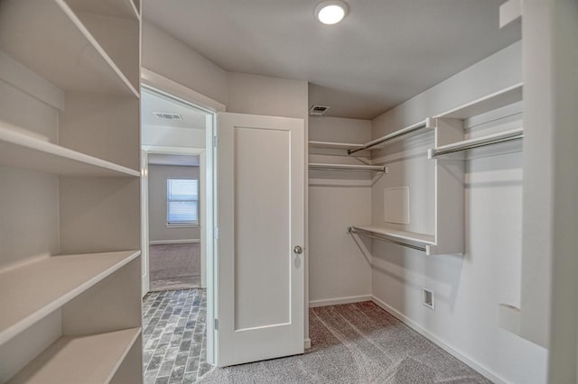 walk in closet with visible vents and carpet flooring